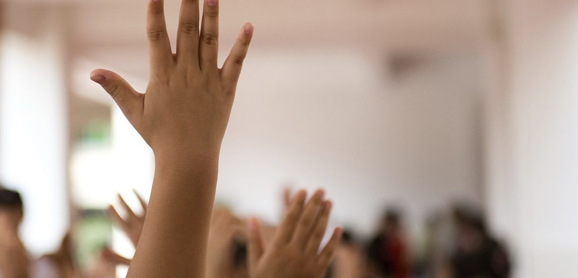 Image of children raising their hands.